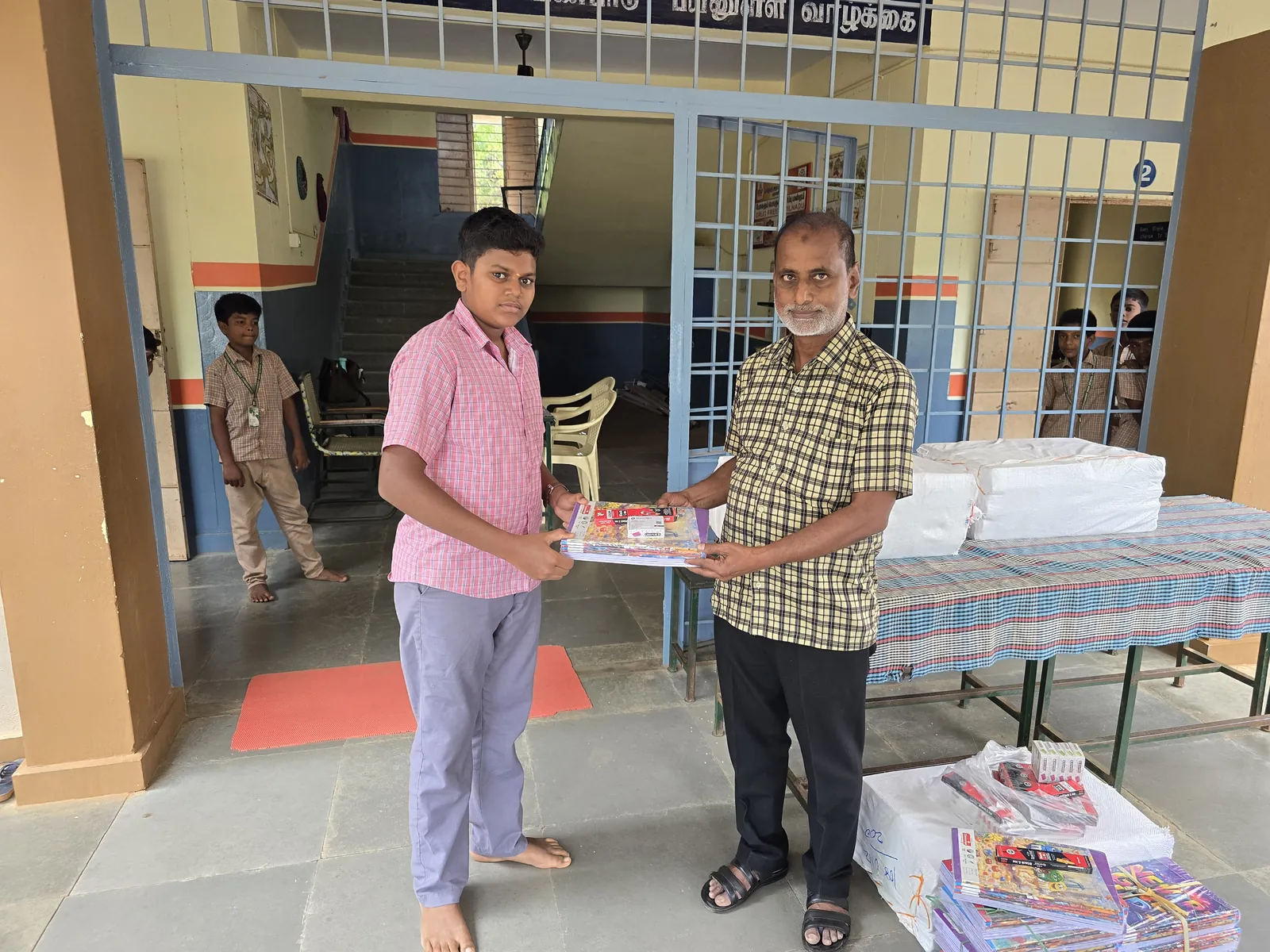 Notebooks being handed out to students at Pangunatham Kottai